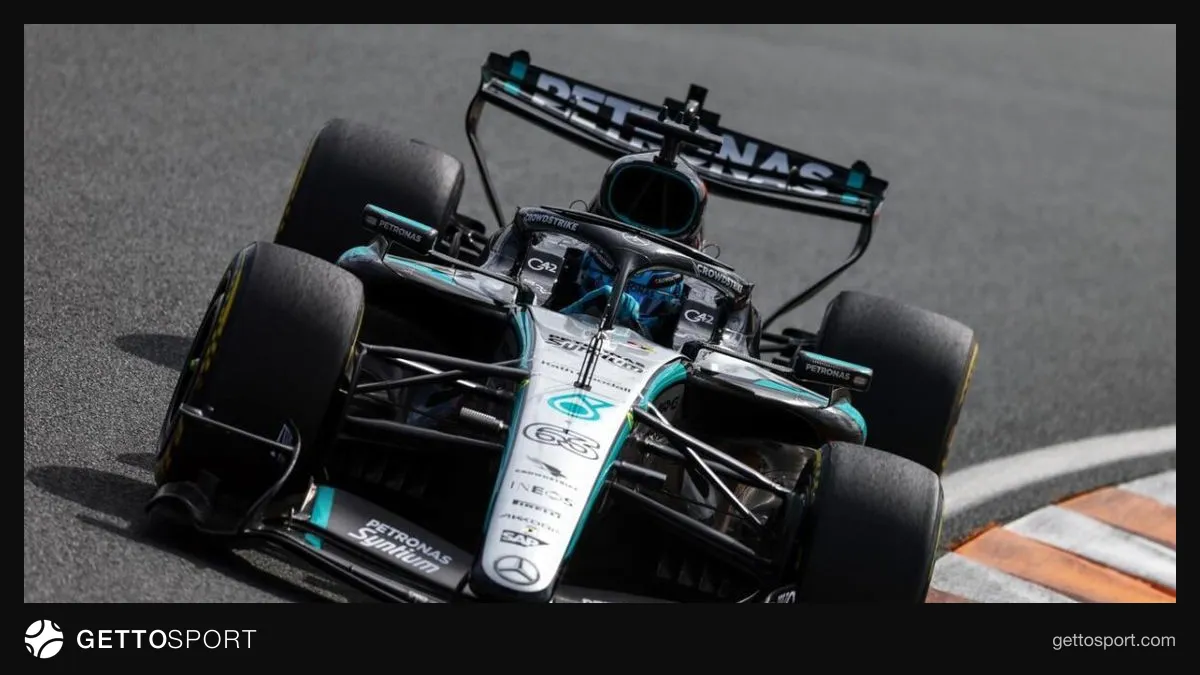 Formula 1 bolidinin arxa qanadı və pitdə texniki işçilər