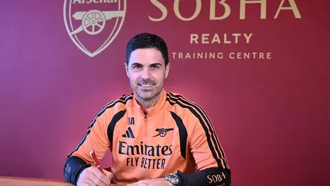 Mikel Arteta Arsenal formasının yanında, klubun loqosu fonunda