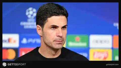 Mikel Arteta mətbuat konfransında danışır, Arsenal loqosu fonunda