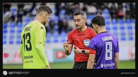 Hakimlər futbol matçı zamanı müzakirə aparır