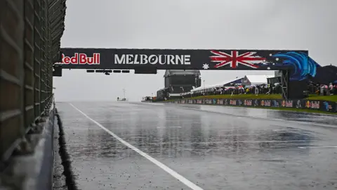 Yağmur altında boş Phillip Island pisti ve üstü kapalı motosikletler