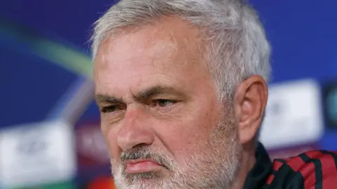 Joze Mourinyo mətbuat konfransında, arxa planda futbol stadionu