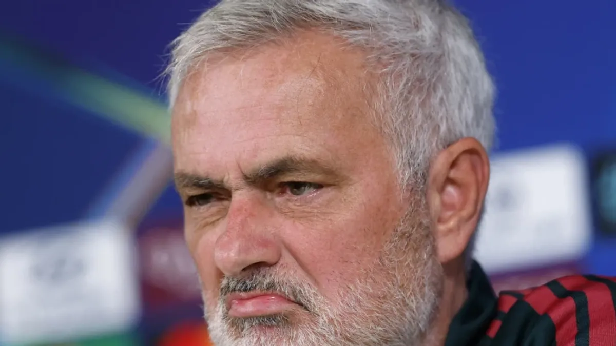 Joze Mourinyo mətbuat konfransında, arxa planda futbol stadionu