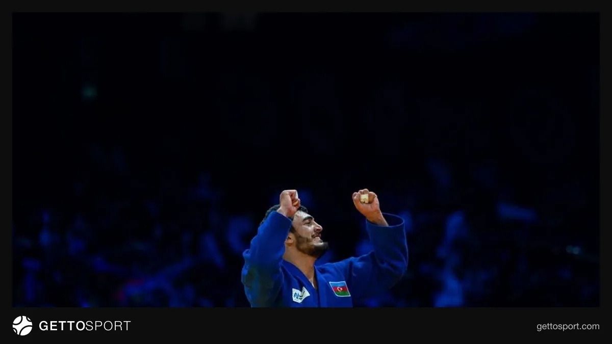 Murad Fətəliyev medal ilə podiumda, azarkeşlər fonunda