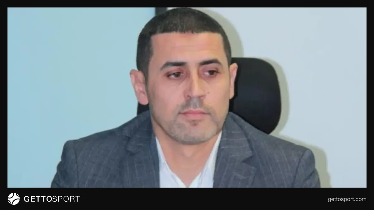Nadir Nəbiyev mikrofona danışır, fonunda futbol arenası