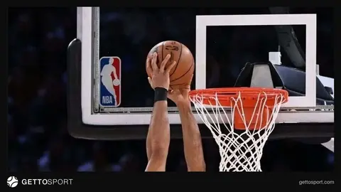 Adam Silver mikrofon önünde konuşuyor, arkada basketbol topu ve saha