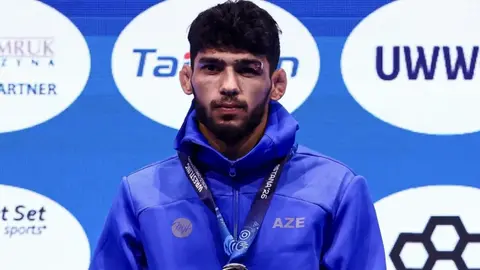Nihat Məmmədli xalqa və kameraya baxarkən, medalı ilə