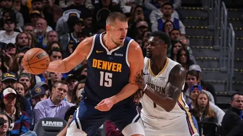 Nikola Jokic maçta top sürerken takım arkadaşlarıyla sevinç