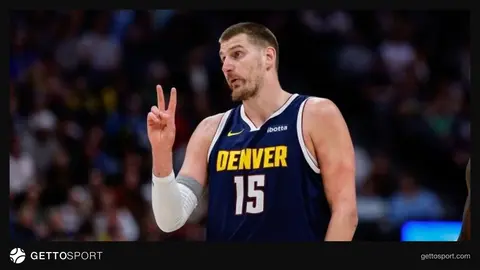 Nikola Jokic maç formasıyla pota altında top sürerken