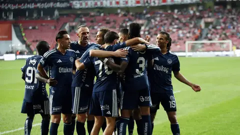 Oğuz Aydın Fenerbahçe formasıyla top sürerken tribünde izleyiciler