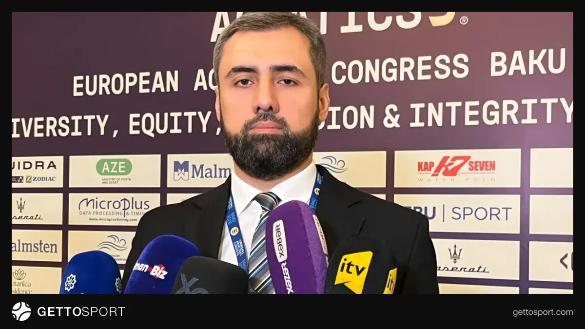 Oqtay Atayev jurnalistlərə açıqlama verir, arxa planda konqres loqosu