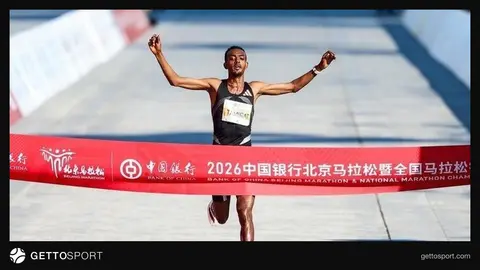 Pekin Maratonu'nda finiş çizgisini geçen atletler ve Olimpiyat Parkı