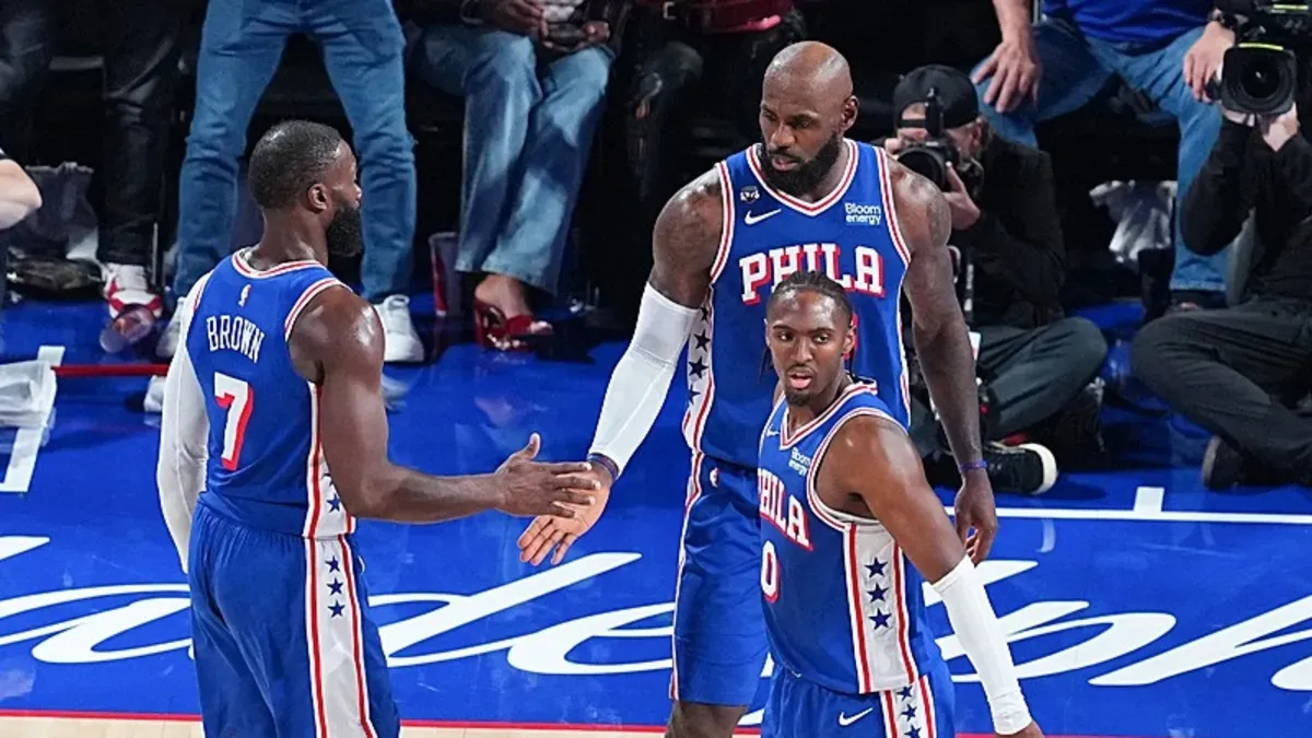 Philadelphia 76ers oyuncuları maçta sevinç yaşarken, Tyrese Maxey top sürüyor