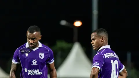 Hakim penalti işarəsi göstərir, futbolçular cəmlənib