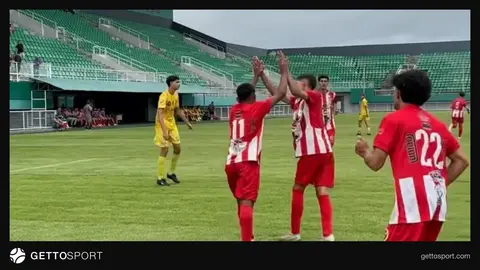 Uşaq futbolçu qol vurarkən və həmyaşlıları sevinir