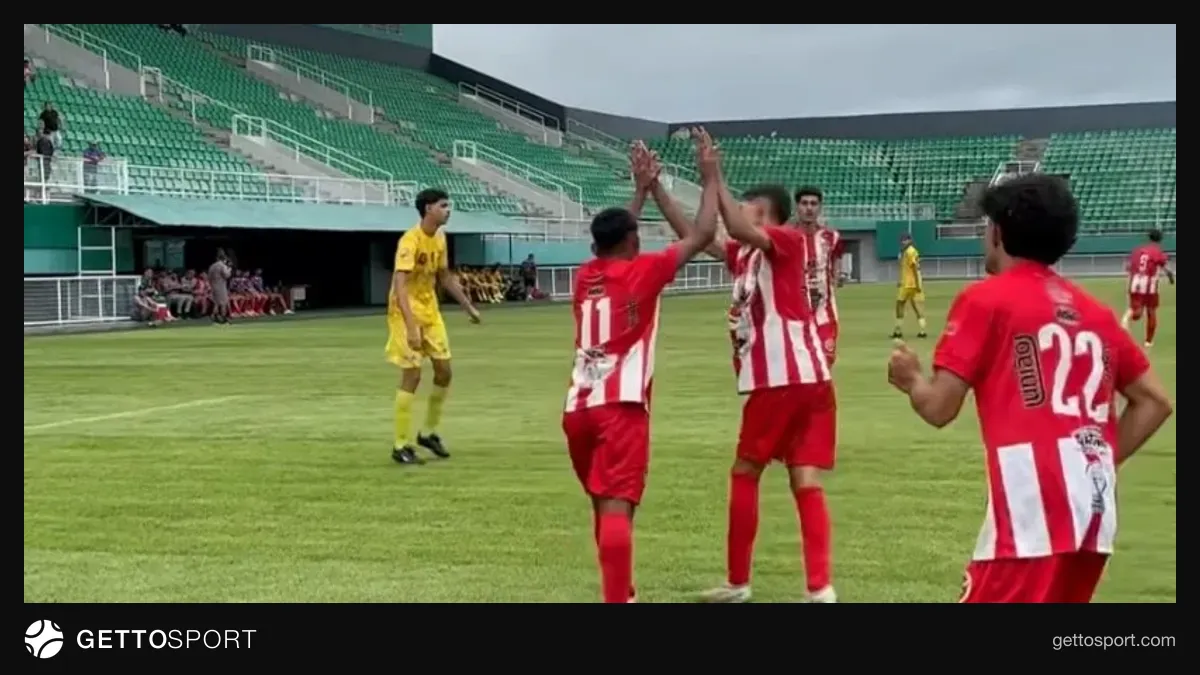 Uşaq futbolçu qol vurarkən və həmyaşlıları sevinir