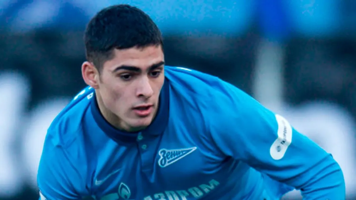 Ramil Şeydayev qışkı formaya bənzər geyimdə, top və stadion fonunda