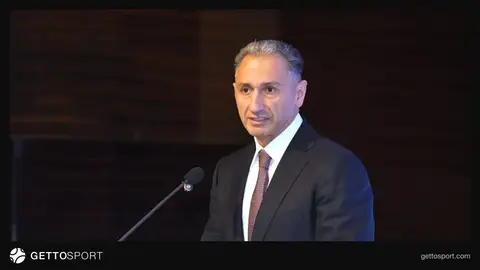 Rəşad Nəbiyev podiumda çıxış edir, arxada cüdo çempionatının açılışı