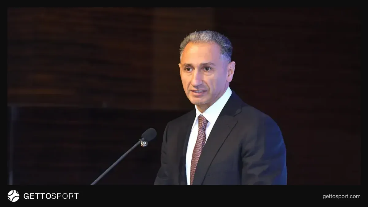 Rəşad Nəbiyev podiumda çıxış edir, arxada cüdo çempionatının açılışı