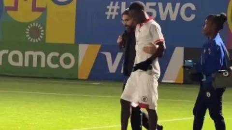 Rövşən Nəcəf stadionda zədələnmiş futbolçuya kömək edir