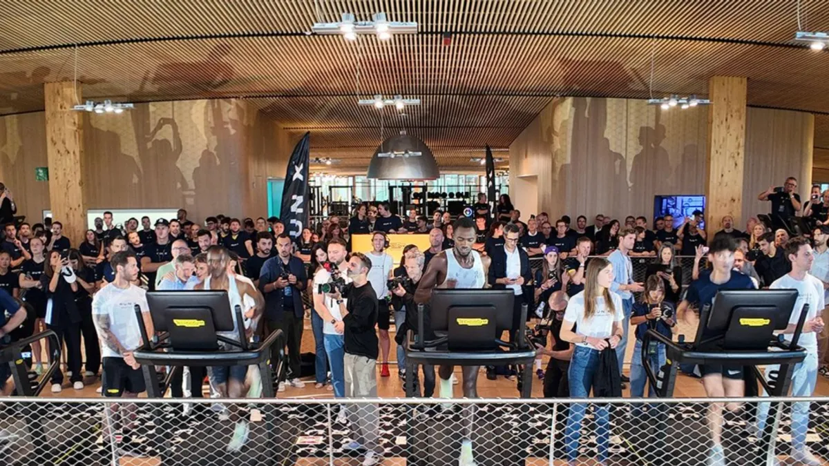 Technogym trenajorunda qaçış edən idmançı və RUN X loqosu