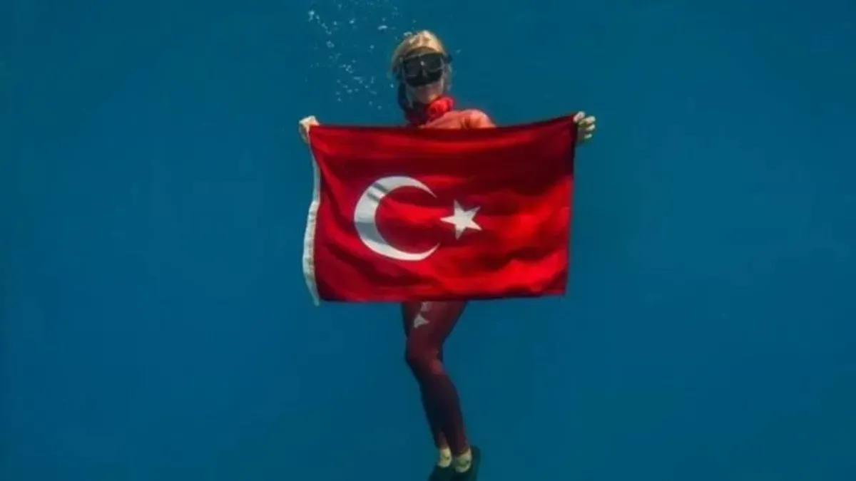 Şahika Ercümen su altında Türk bayrağıyla