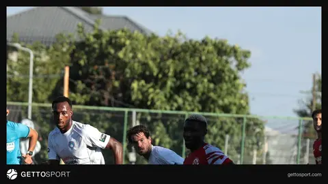 Stadionda topa hücum edən futbolçu silueti