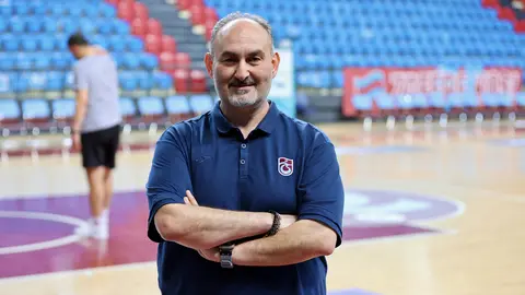 Selçuk Ernak basın toplantısında konuşuyor, arka planda Trabzonspor logosu