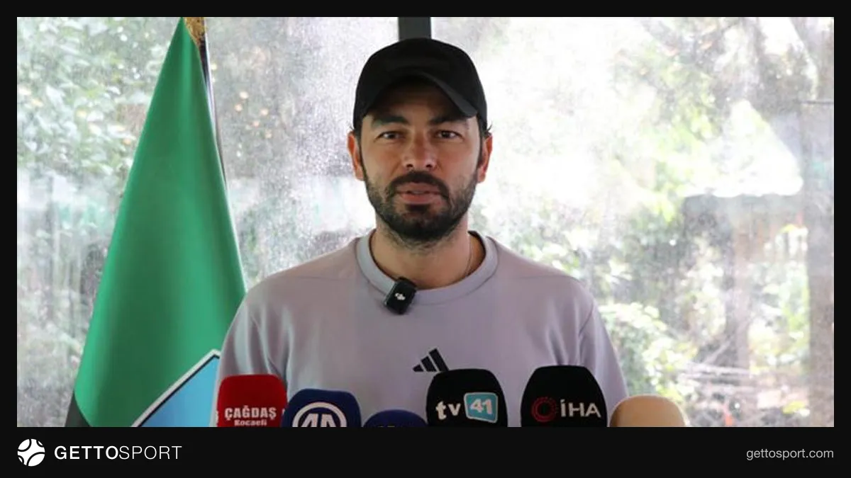 Selçuk İnan antrenman öncesi konuşurken, Kocaelispor oyuncuları sahada çalışıyor