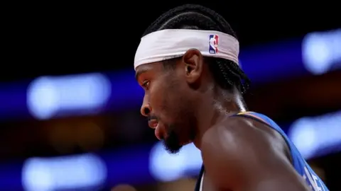 Shai Gilgeous-Alexander maç sırasında kenarda otururken konuşuyor