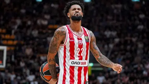 Tayler Dorsi Olimpiakos formasında, üzünə tərəf kamera