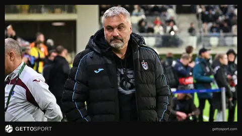 Thomas Reis basın toplantısında konuşurken, arka planda Trabzonspor logosu