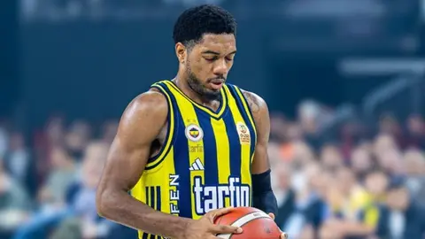 Trent Forrest Fenerbahçe formasıyla saha kenarında röportaj verirken görüntüsü
