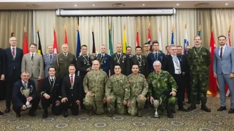 Vahap Şanal madalya alırken satranç tahtası önünde zafer pozu