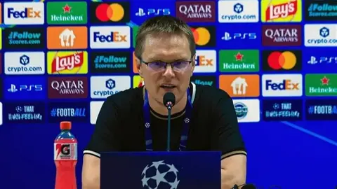 Valdas Dambrauskas mətbuat konfransında, arxa planda futbol stadionu
