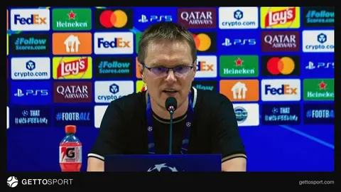 Valdas Dambrauskas mətbuat konfransında, arxa planda futbol stadionu
