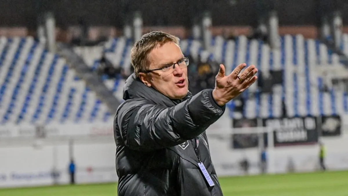 Valdas Dambrauskas mətbuat konfransında, arxada futbol stadionu