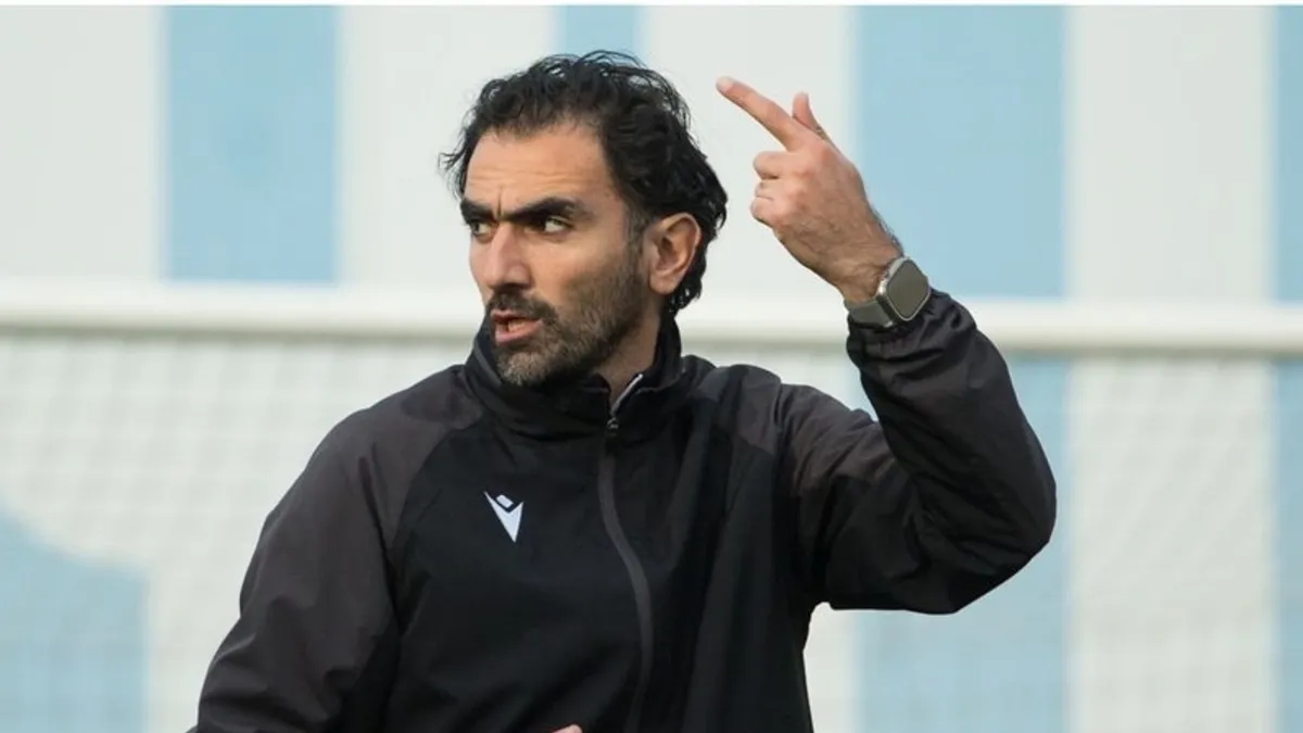Vaqif Cavadov mətbuat önündə danışır, arxa planda U-15 mundial afişası