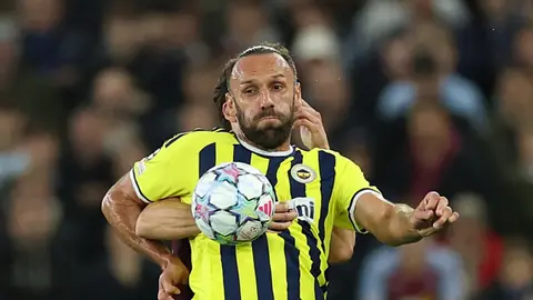 Vedat Muriç basın açıklaması yaparken takım formasıyla konuşuyor