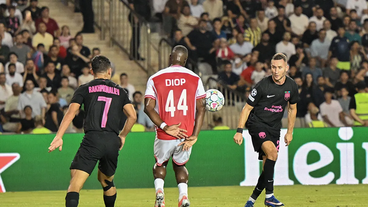 Velko Simiç futbol formasında mətbuat önündə danışır