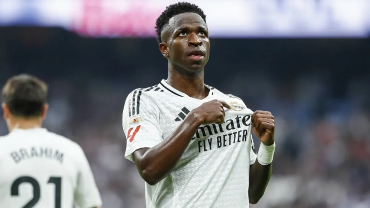 Vinisius Junior ağ rəngli Real Madrid formanında topa doğru qaçır