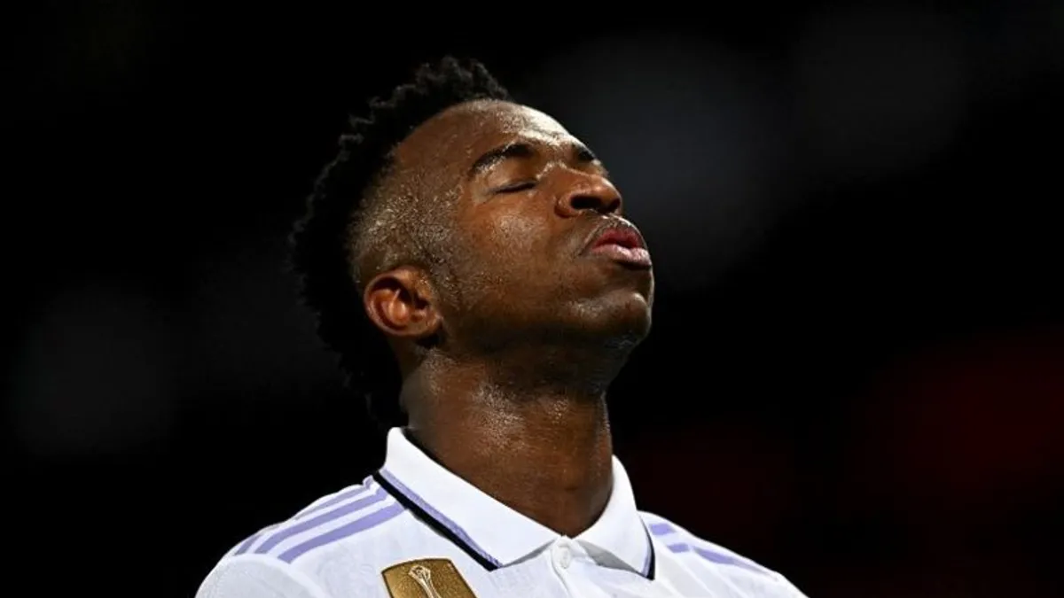 Vinisius Junior topa nəzarət edir, Arsenal və Real Madrid loqotipləri fonunda