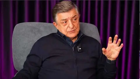 Yılmaz Vural konuşurken mikrofon önünde canlı yayın görüntüsü