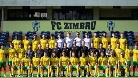 Zimbru klubunun loqosu və boş stadion tribunası